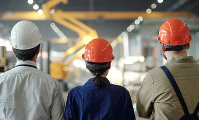 3 personer ser på en tillverkningsprocess