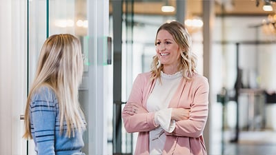 Kvinna i rosa kavaj med armarna i kors