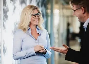 Kvinna i blå skjorta och svarta glasögon som talar om fakturaköp 
