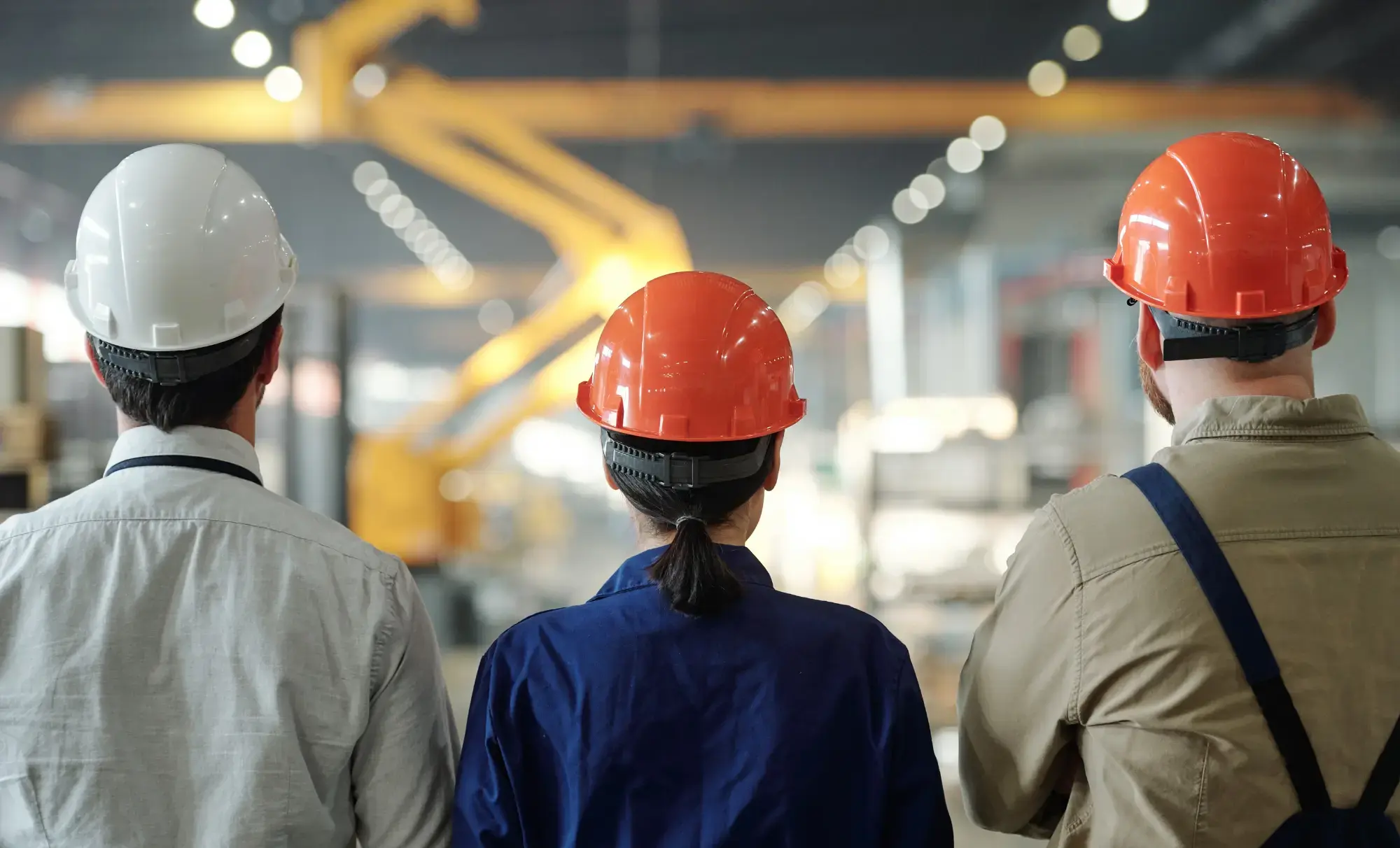 3 personer ser på en tillverkningsprocess image